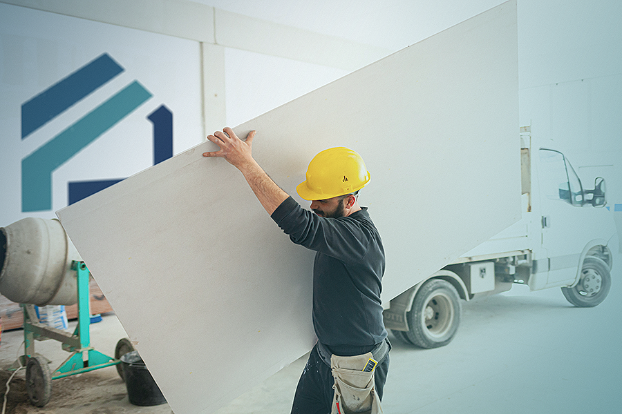 A man carries a sheetrock panel across the photo with a Florida restoration services logo on the background.
